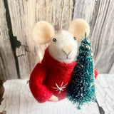 Felted mouse ornament in a red sweater with a small Christmas tree against a wooden background