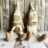 Two decorative gnomes with a rustic wooden background