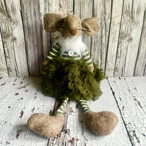 Moss-covered gnome figurine with a striped sweater on a rustic wooden background