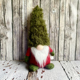 Gnome figurine with a green hat on a wooden background
