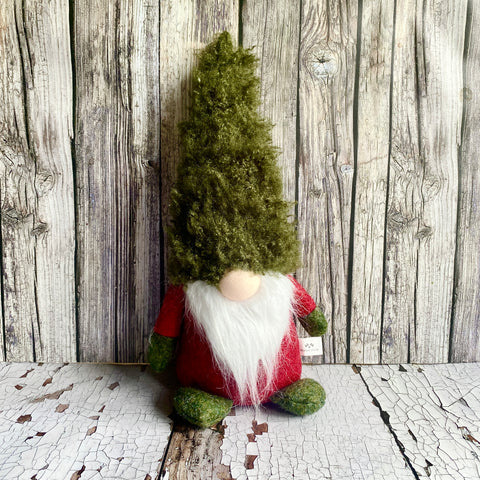 Gnome figurine with a green hat on a wooden background