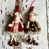 Two decorative mice tree ornaments on a textured white and brown background