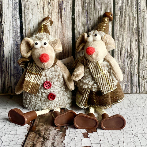Two stuffed animal mice with knitted outfits on a rustic wooden background.