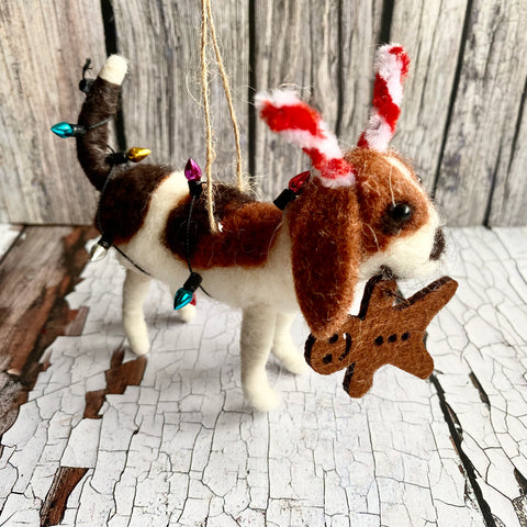 Decorative dog ornament eating a gingerbread man on a rustic wooden surface