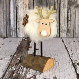 Wooden Deer on a log with a white fur coat